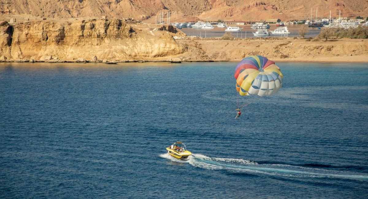 Enjoy a thrilling parasailing experience with stunning coastal views and a colorful parachute.
